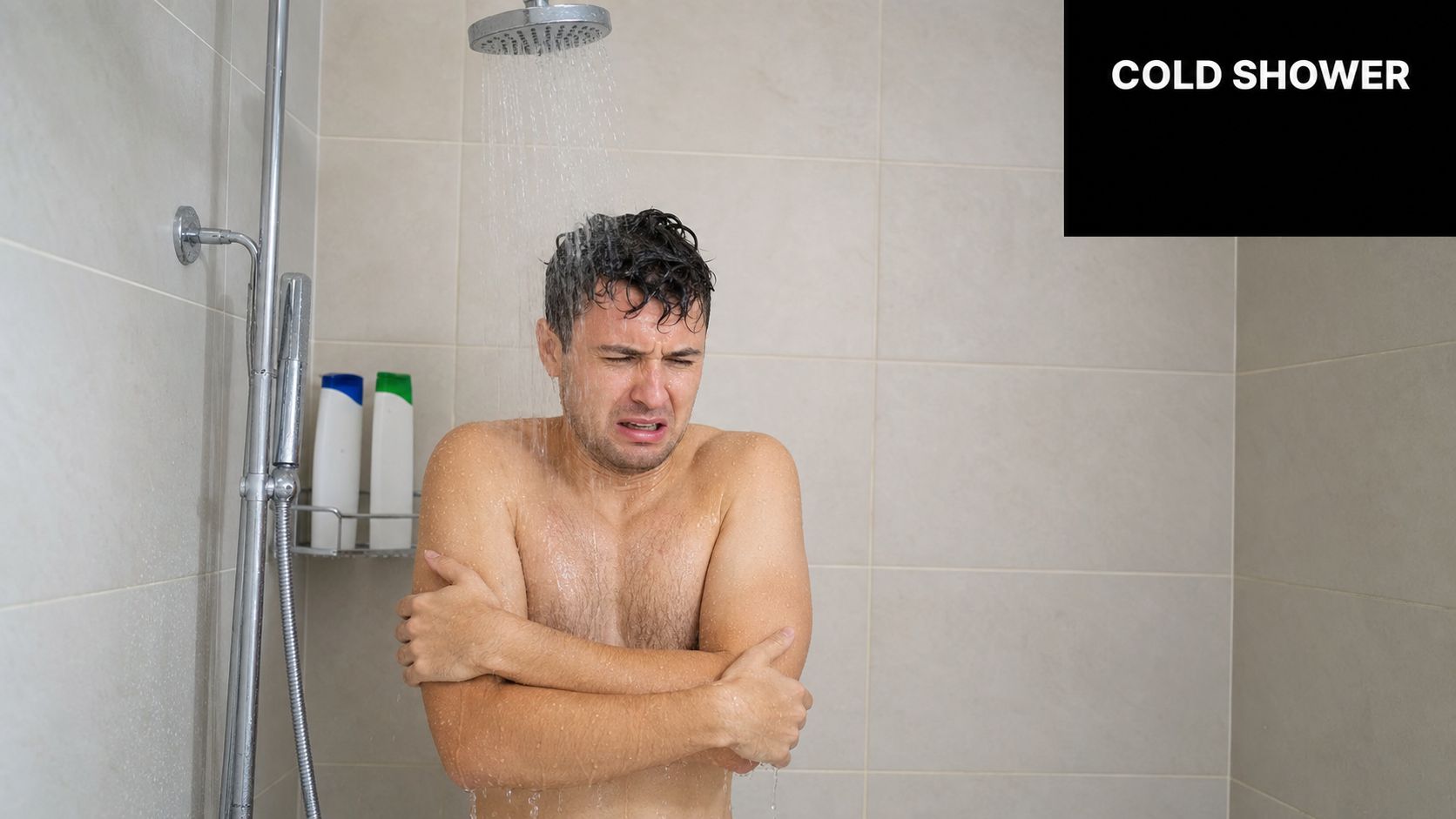 A man looking uncomfortable and shivering while taking a cold shower under a showerhead in a bathroom.